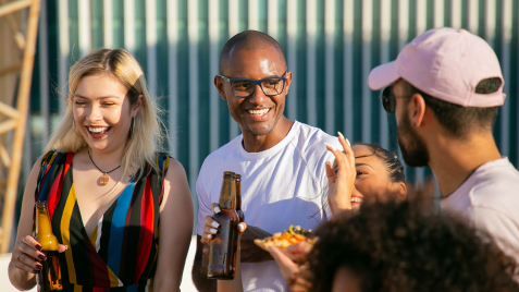 Friends enjoying beers and food together outside.